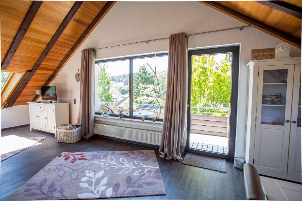 a living room with a large window and a door at Ferienwohnung Ruhenest in Willingen