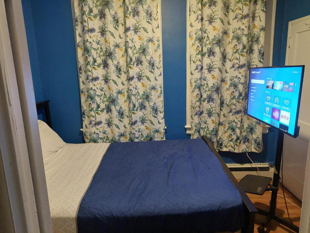 a bedroom with a bed and a computer monitor at 1052grovest in Irvington