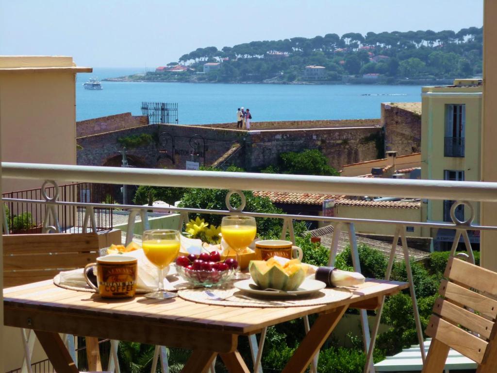 a table with glasses of orange juice on a balcony at Cap View in Antibes