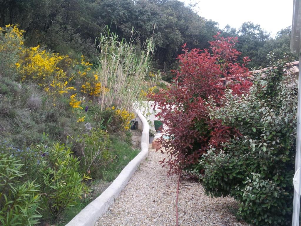 a path through a garden with flowers and plants at Les Garrigues Bleues in Tornac