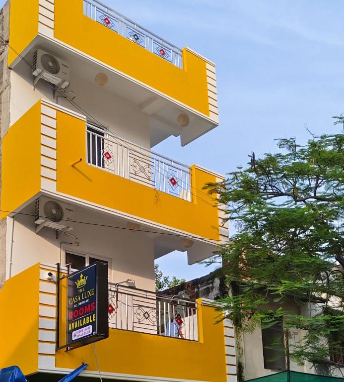 a building with yellow balconies and a sign on it at The Casa Luxes in Pondicherry