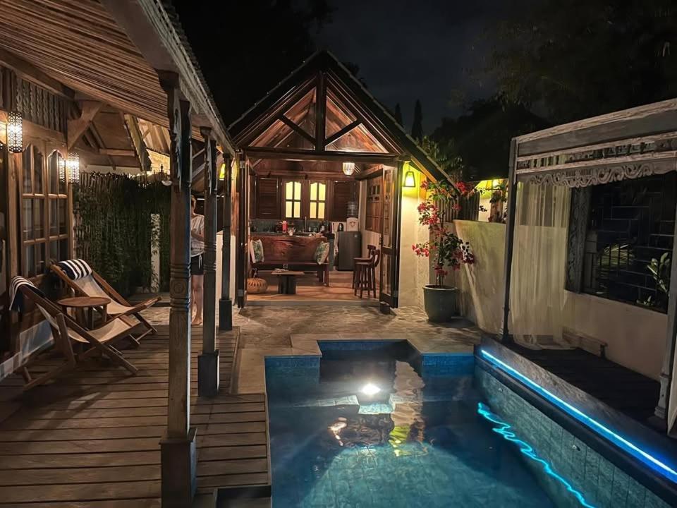 克罗柏坎Villa Bliss - 1BR Tropical Villa in Kerobokan的后院,晚上设有游泳池