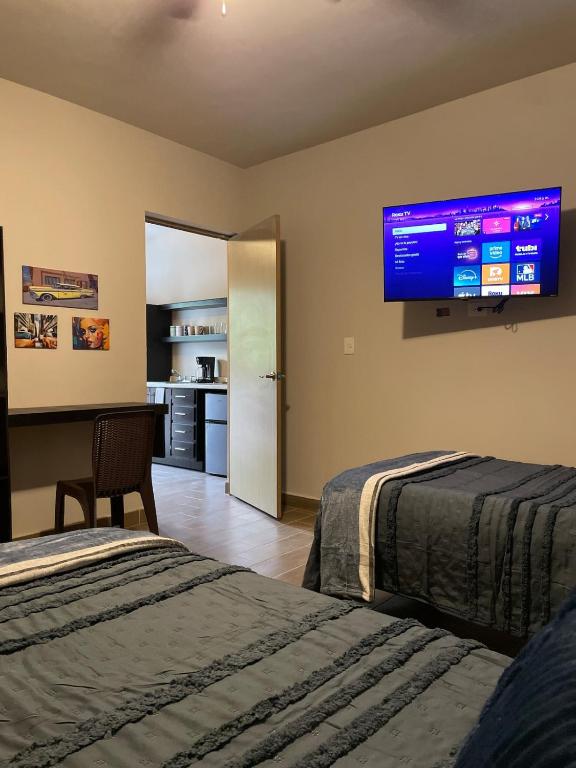 a hotel room with two beds and a flat screen tv at LiV109 Norte Depa 8 Cd Obregon in Ciudad Obregón