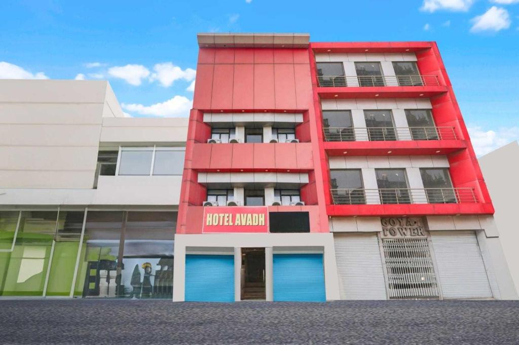 a red building with blue doors in a street at Hotel O Durgapuri Metro Station Lucknow Formerly Pal Awadh in Bādshāhnagar