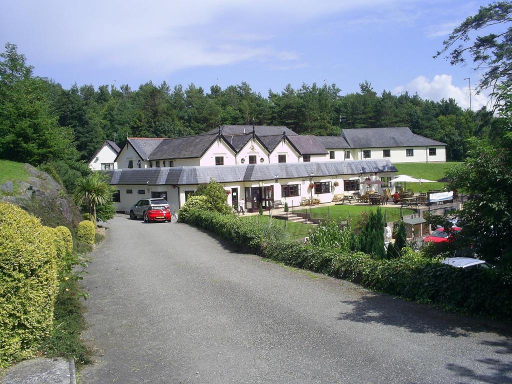 a large house on a hill with a driveway at Carreg Bran in Llanfairpwllgwyngyll