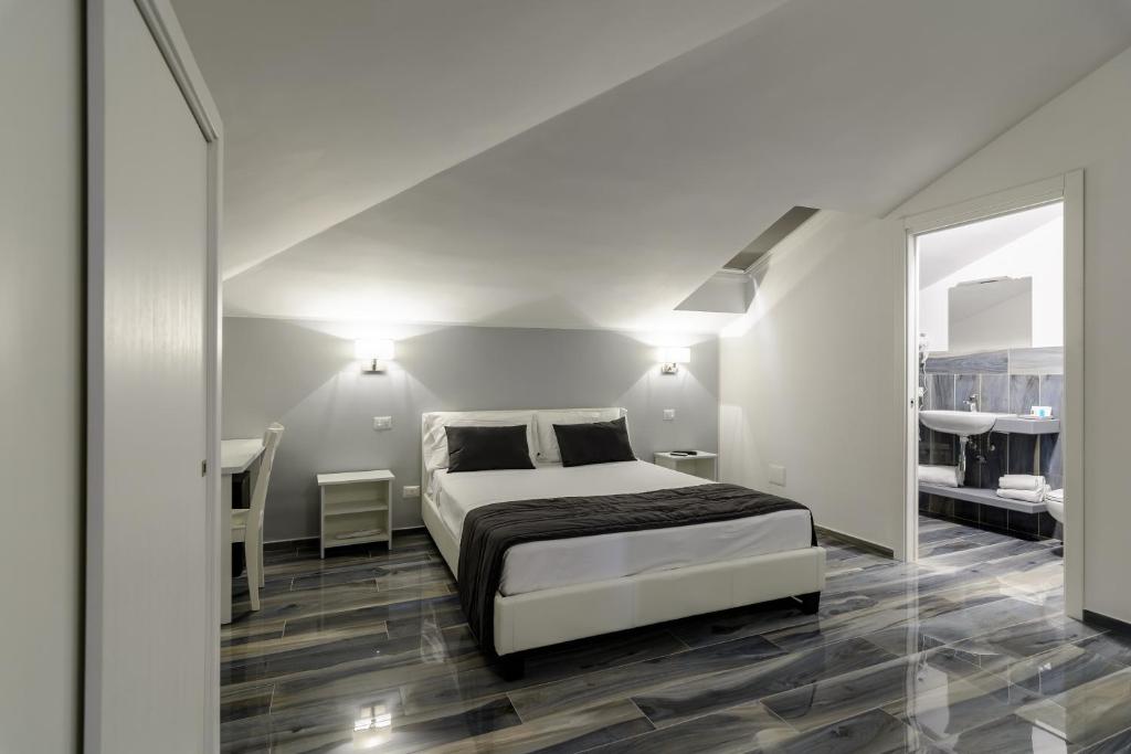 una camera bianca con un letto e due tavoli di B&B al Palazzo ad Agropoli