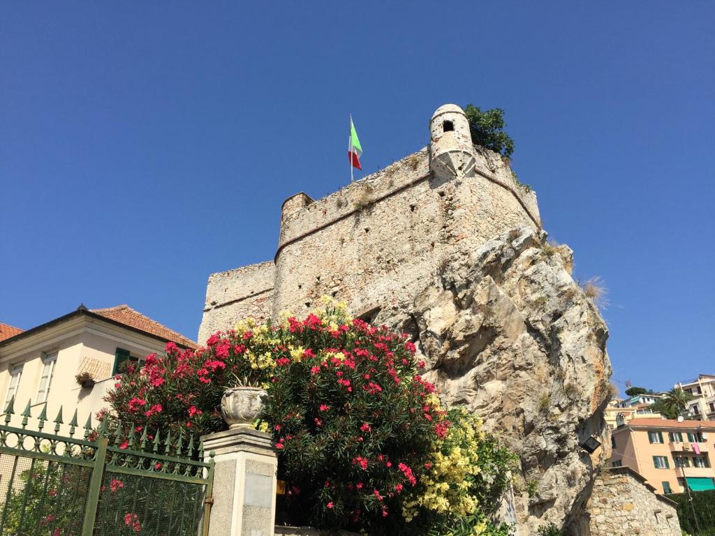 kamienna ściana z kwiatami przed budynkiem w obiekcie Al Castello Affittacamere w mieście Pietra Ligure