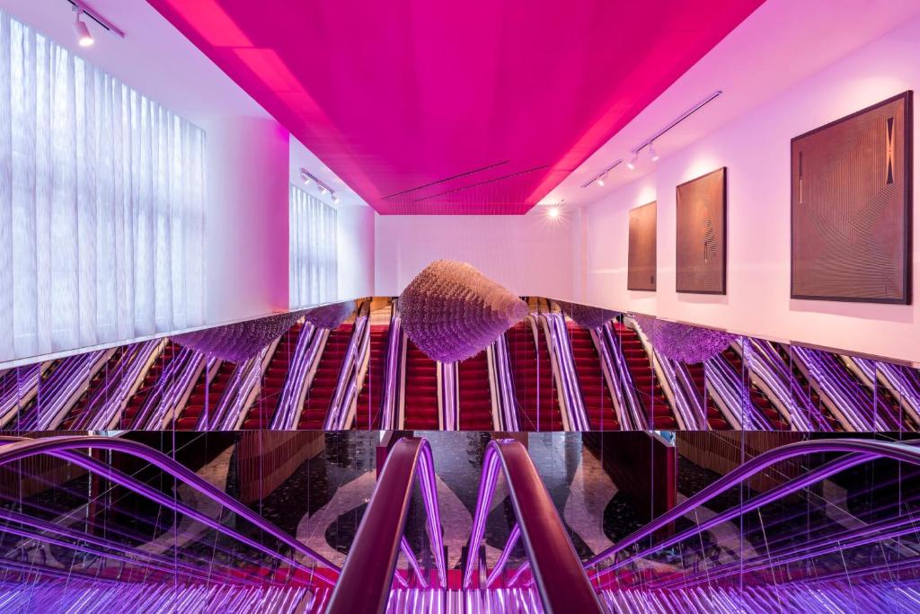 um bar com iluminação roxa em uma sala em Andaz Condesa Mexico City, By Hyatt em Cidade do México