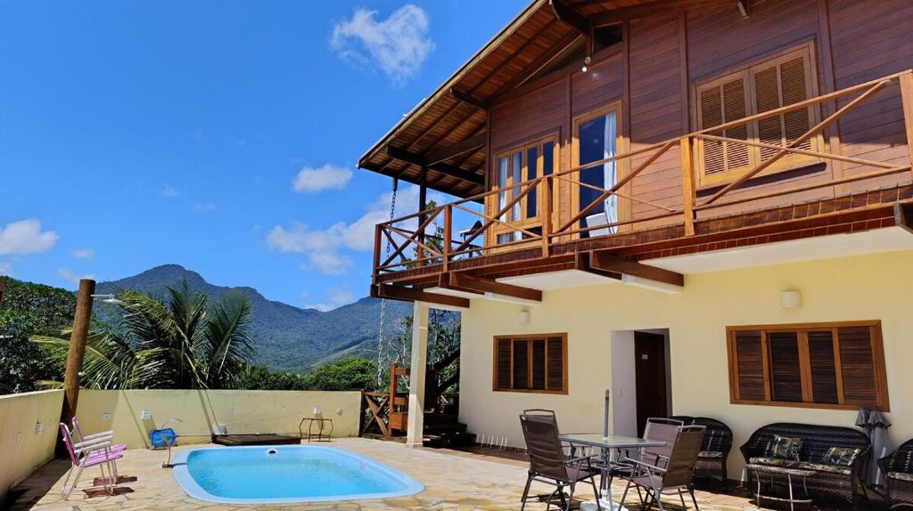 a villa with a swimming pool and a house at Casa Mar A Vista in Ilhabela