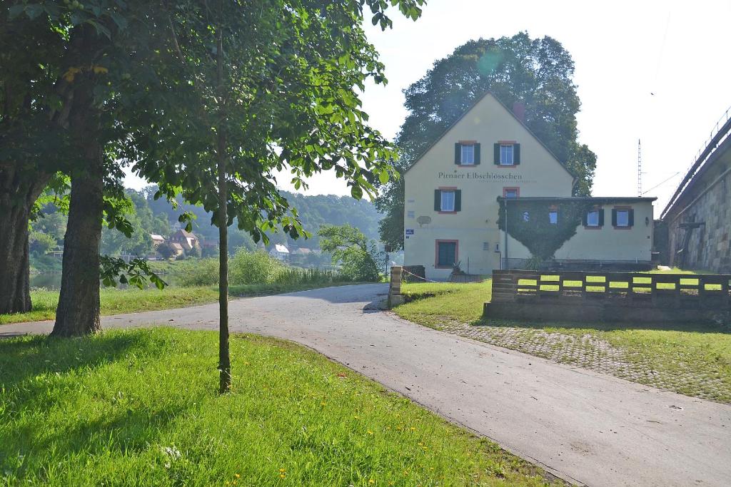 ein weißes Haus am Straßenrand in der Unterkunft Elbschlösschen Refugium in Pirna