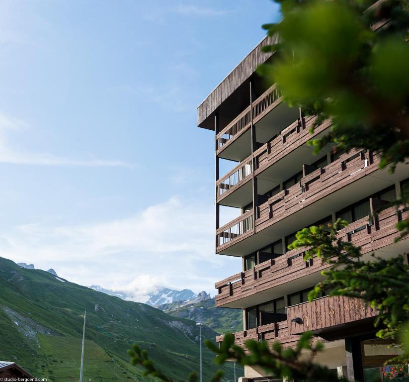 a building with balconies and mountains in the background at Résidence Pierre & Vacances Inter-Résidences in Tignes