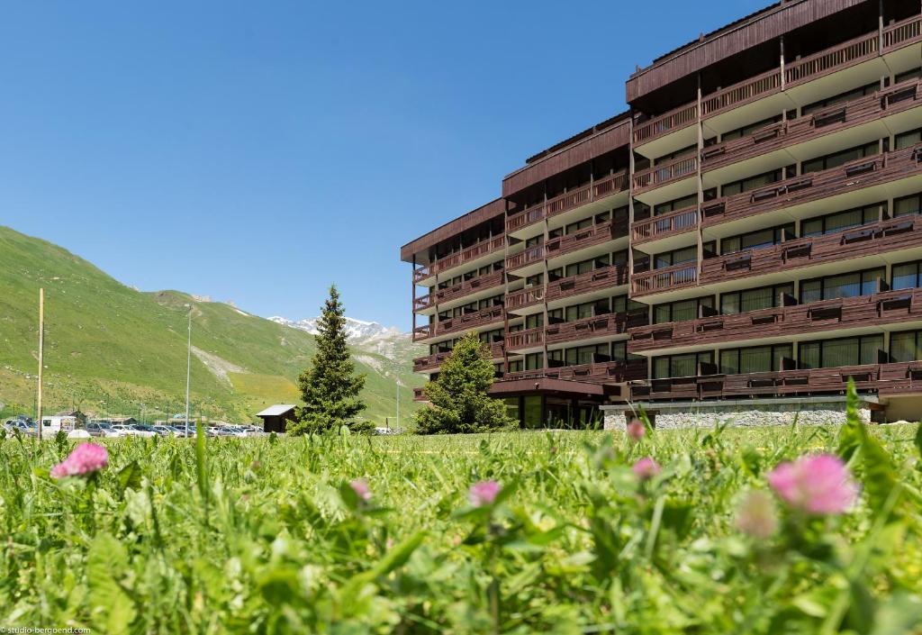 a building with a field of flowers in front of it at Résidence Pierre & Vacances Inter-Résidences in Tignes