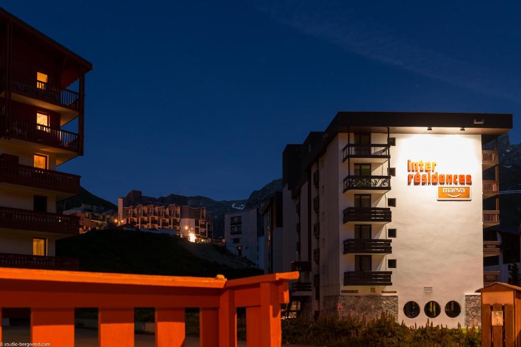 a building with a sign on the side of it at night at Résidence Pierre & Vacances Inter-Résidences in Tignes