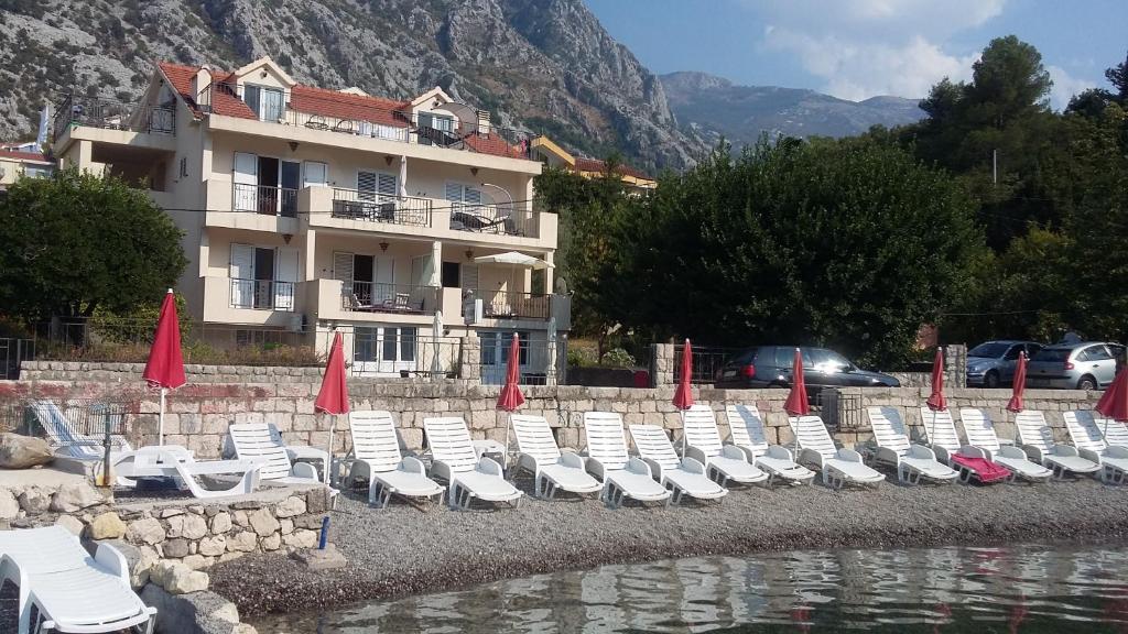 a group of chairs and umbrellas in front of a building at Apartments Pejanović in Kotor