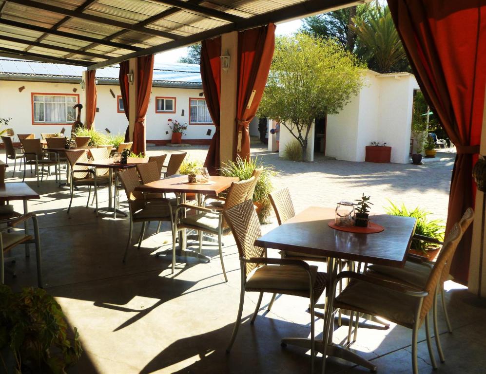 an outdoor patio with tables and chairs in a restaurant at Omaruru Guesthouse in Omaruru