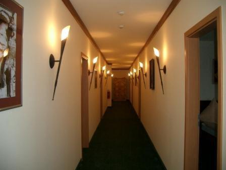 a hallway with a long corridor with lights on the walls at Gasthof Strausberg Nord in Strausberg