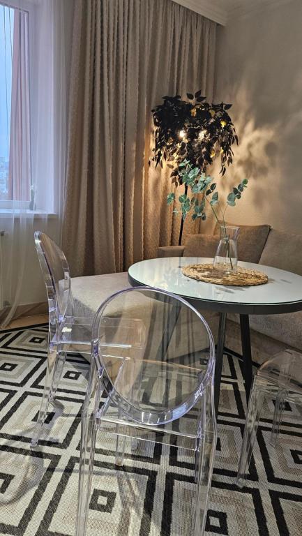 a dining table and chairs in a living room at Black Room Apartment in Mukacheve