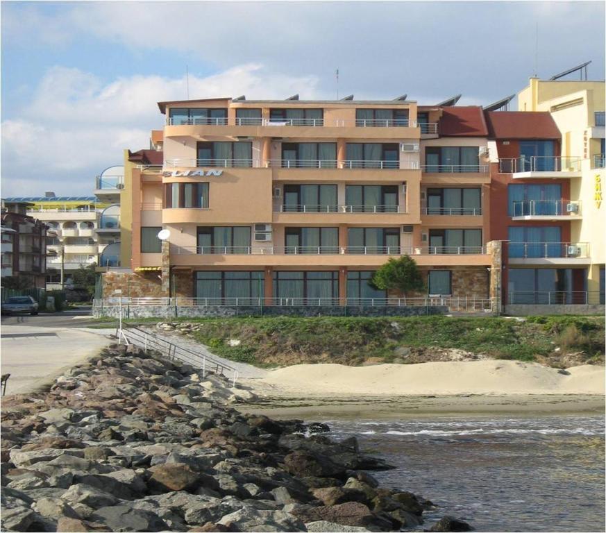 a large building next to a body of water at Hotel Blian in Ravda