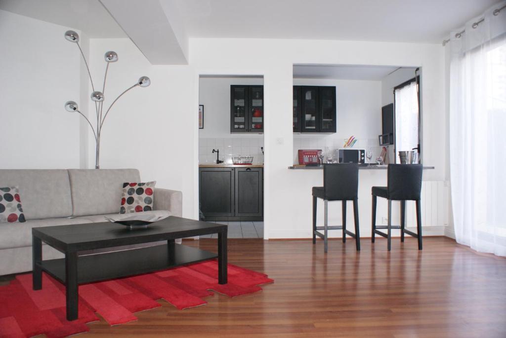 a living room with a couch and a table and chairs at Appartement Le Louvre in Dijon