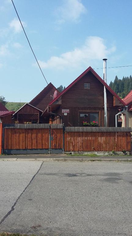 ein Holzgebäude mit einem Zaun und einem Haus in der Unterkunft Chalupa Slota in Gôtovany