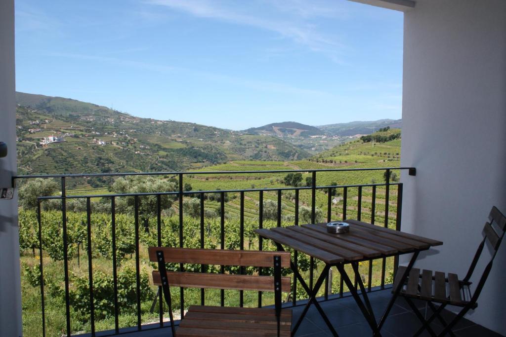 d'une table et de chaises sur un balcon avec vue. dans l'établissement Casa Nª Sra. do Carmo - Villas, à Peso da Régua