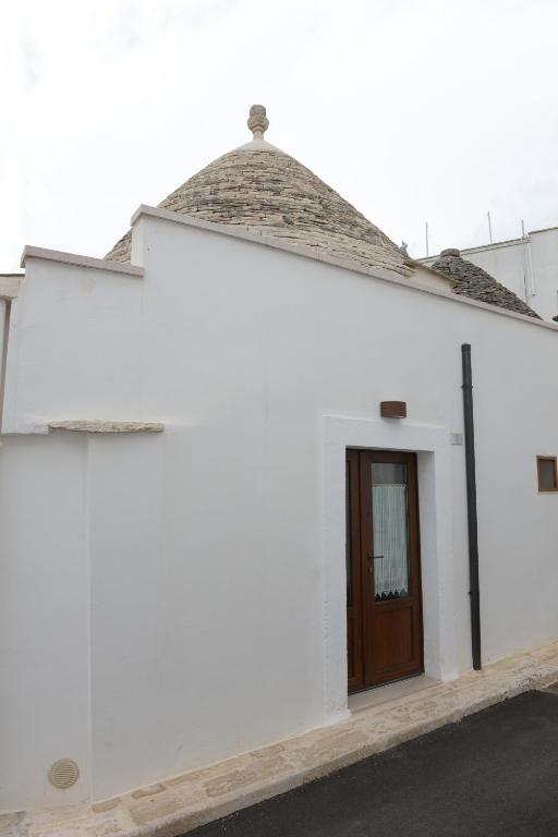 Biały budynek z brązowymi drzwiami w obiekcie Trullo Dimora di Giorgia w Alberobello