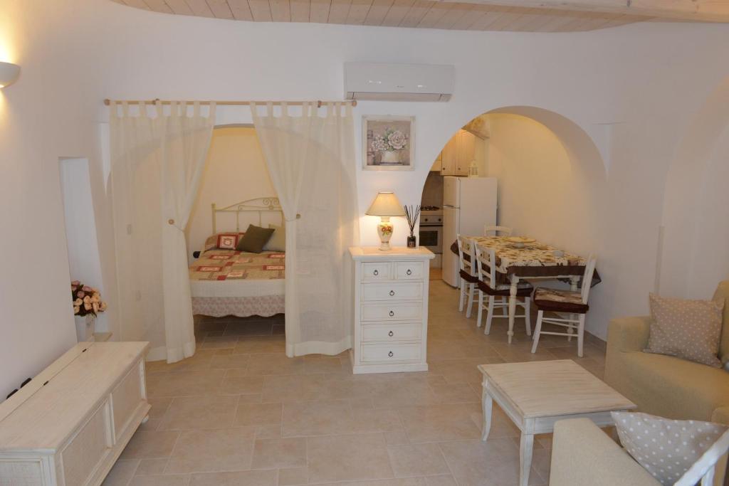 アルベロベッロにあるTrullo Dimora di Giorgiaのベッドルーム1室(ベッド1台付)、ダイニングルーム(テーブル付)
