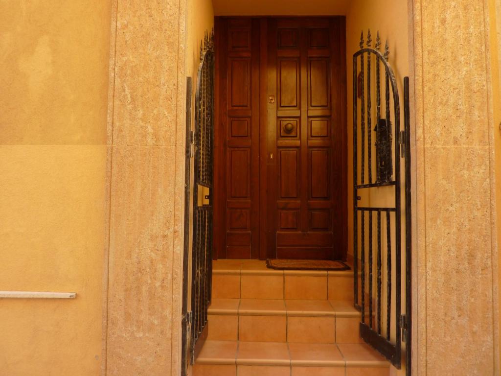 pasillo con puerta de madera y puerta de hierro forjado en Duomo Rent Room & Flat, en Agrigento