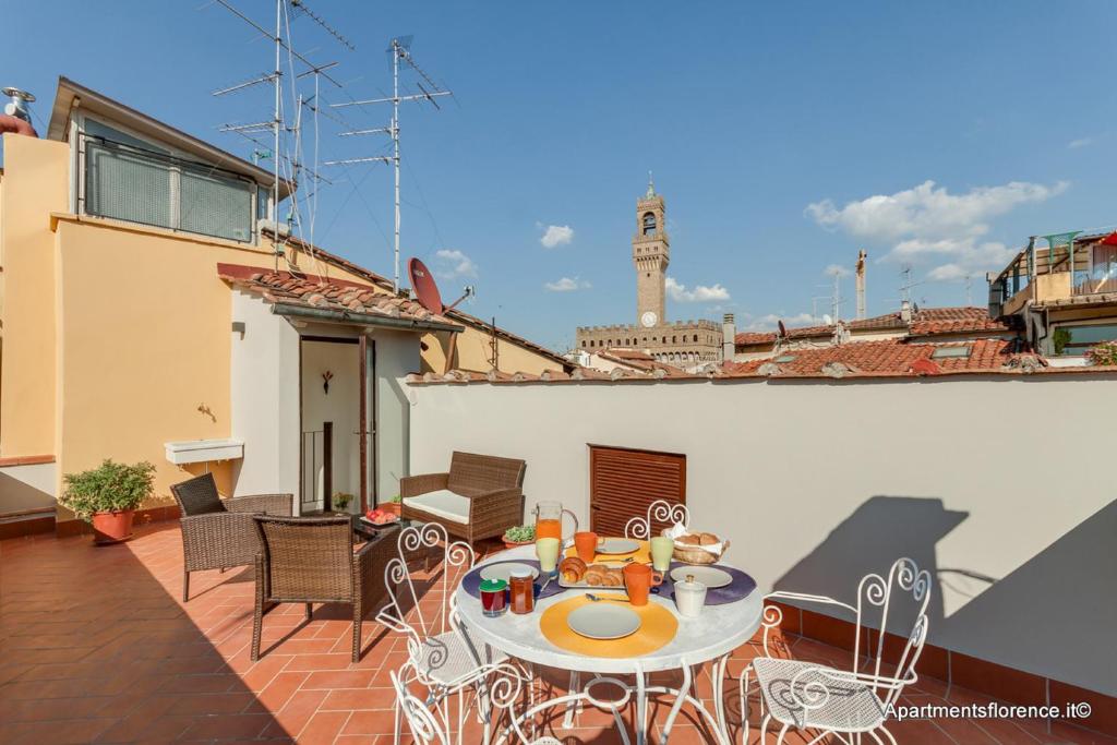 eine Terrasse mit einem Tisch und Stühlen auf dem Balkon in der Unterkunft Apartments Florence - Santa Maria Balcony in Florenz