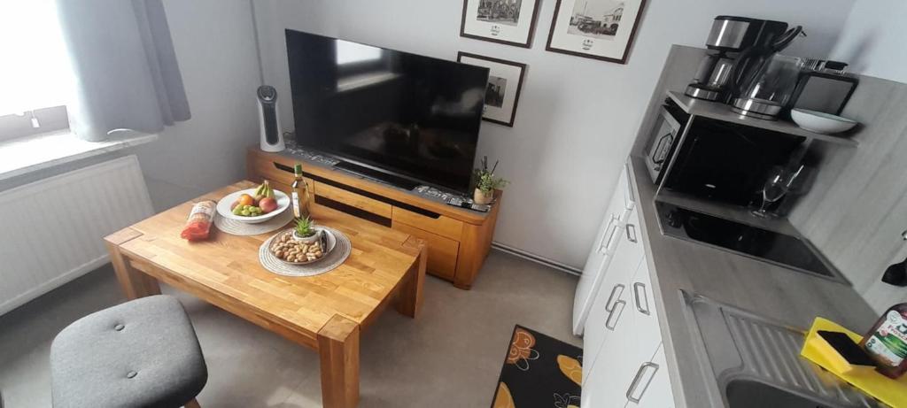 een kleine woonkamer met een tafel en een televisie bij Studio-Apartment Goslar in Wolfenbüttel