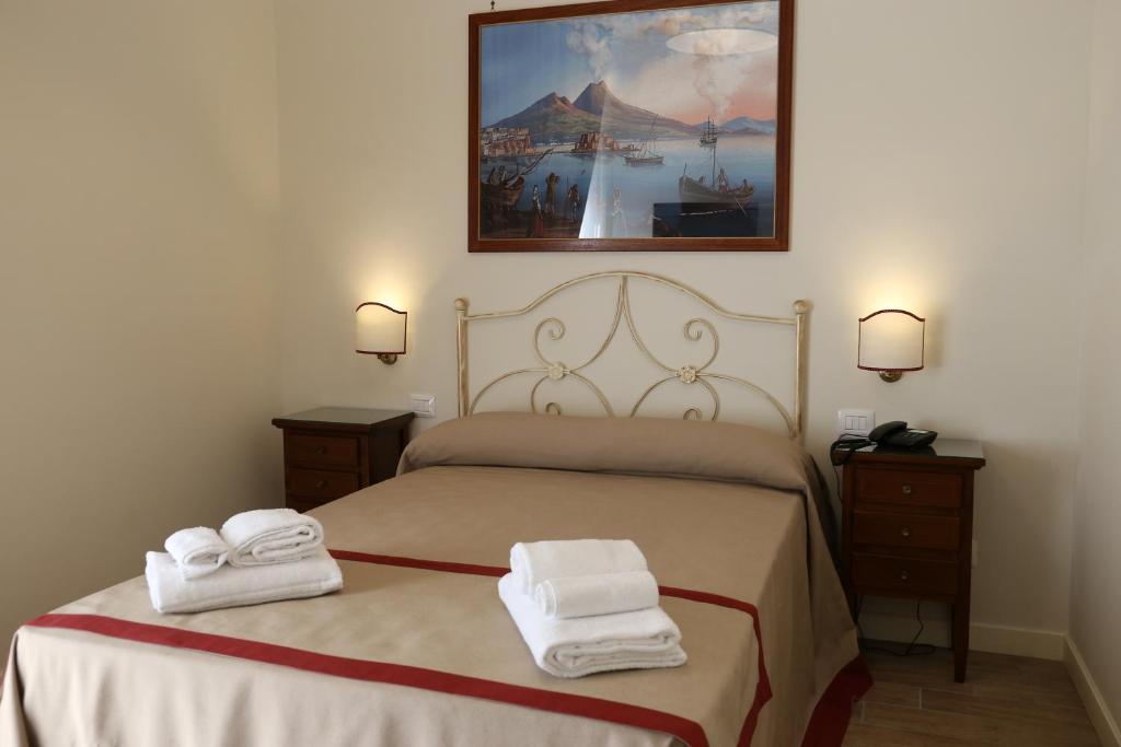 1 dormitorio con 1 cama con toallas en Dimora delle Arti, en Nápoles