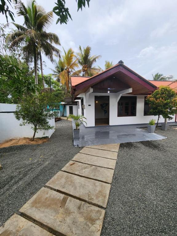 a house with a pathway in front of it at Ryo hostel in Ahangama