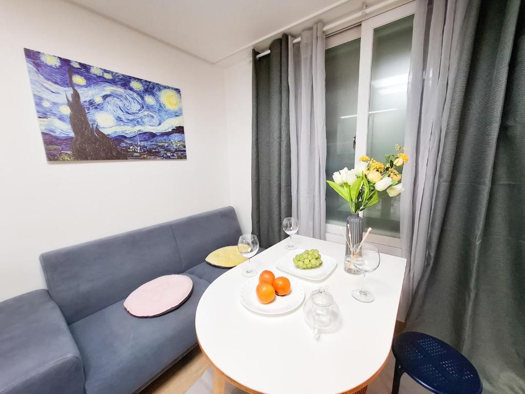 Una sala de estar con una mesa blanca y un sofá. en 금천구 디지털단지 빌라, en Seúl