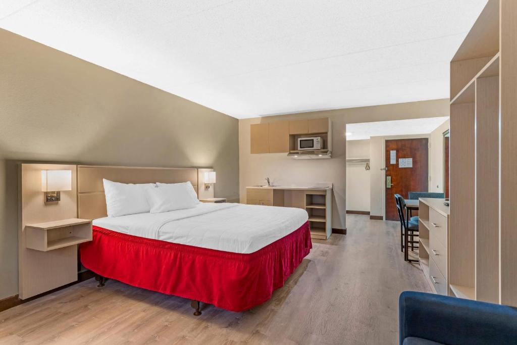 a hotel room with a bed and a kitchen at MainStay Suites Lansing West in Lansing