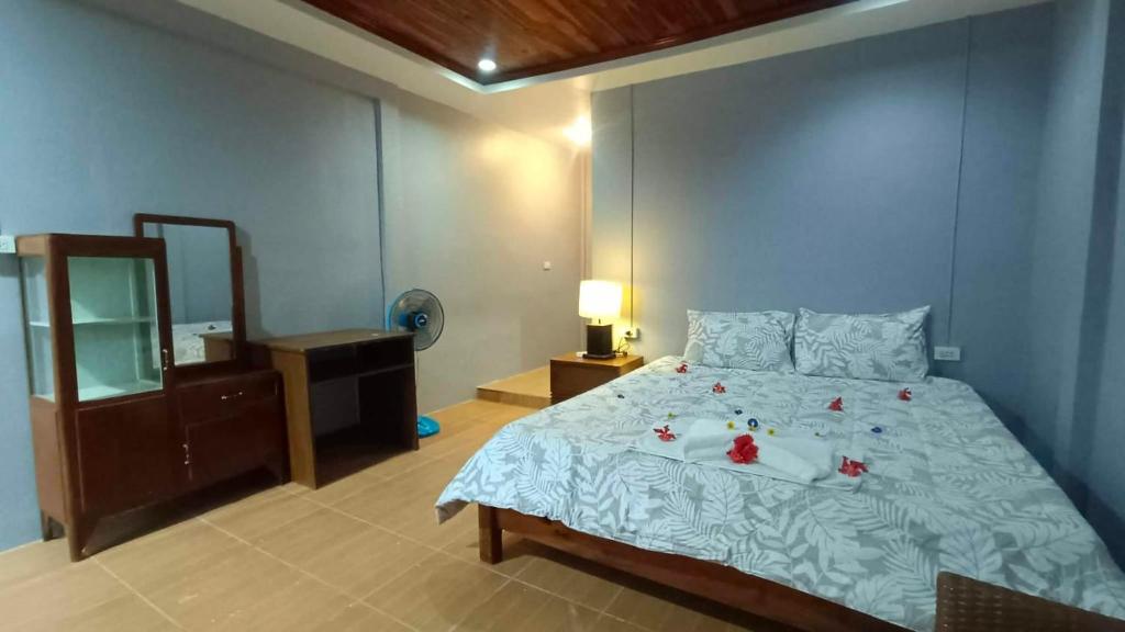 a bedroom with a bed with flowers on it at Friend Guesthouse , Kho Lanta in Ko Klang