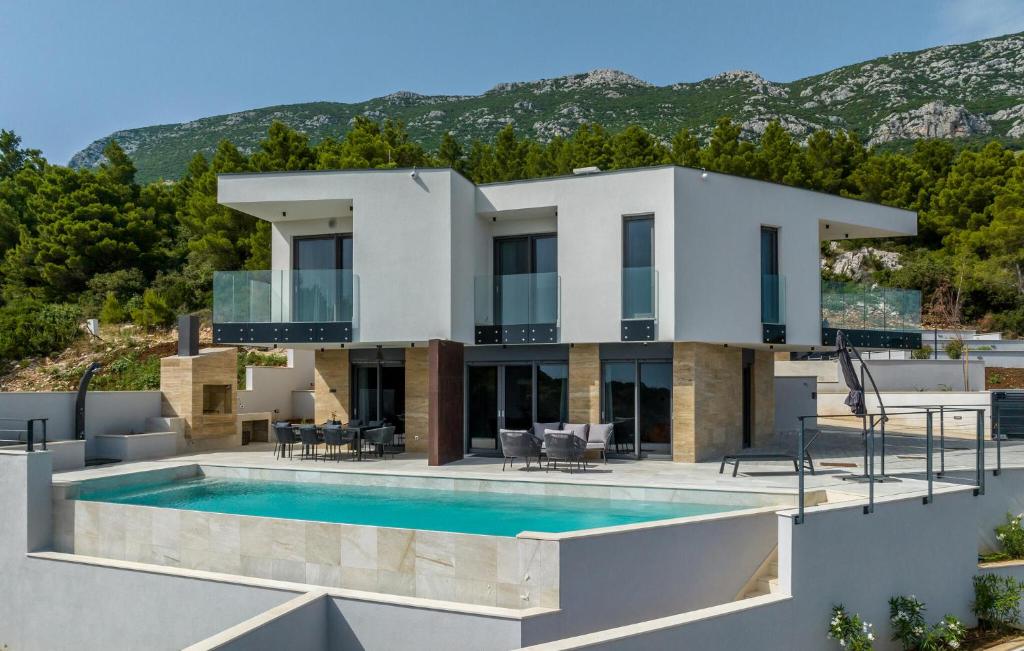 a villa with a swimming pool and a house at Cozy Home In Dingac With Sauna in Gornji Dingač