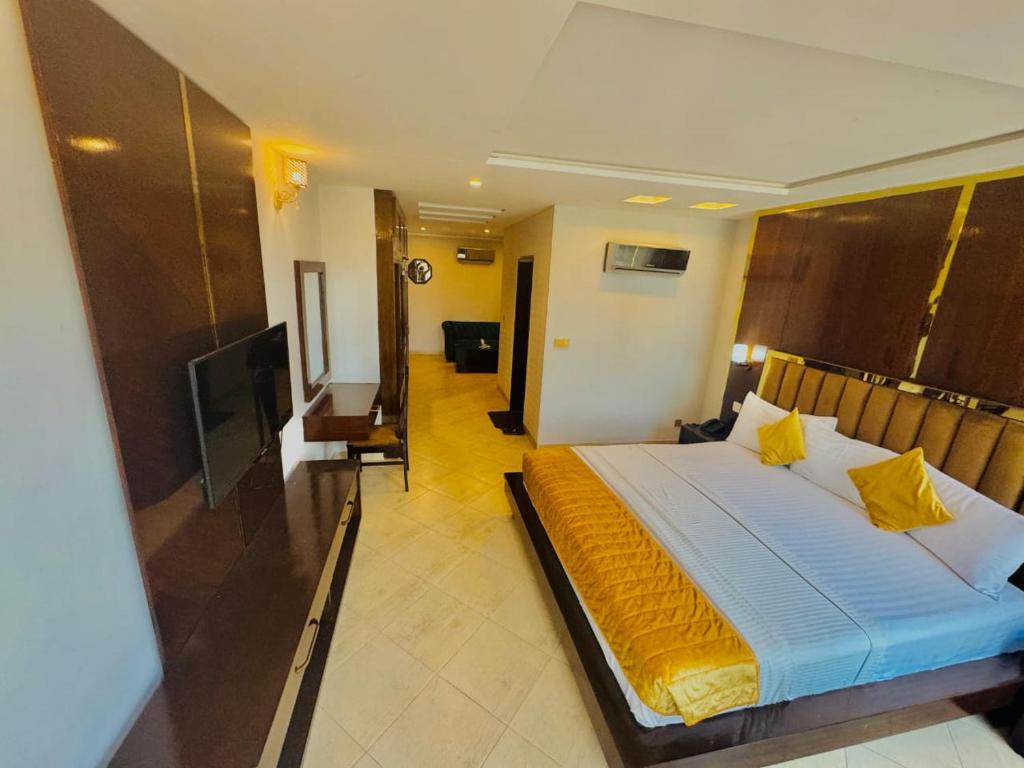 um quarto com uma cama grande com travesseiros amarelos em Hotel in Multan em Multan