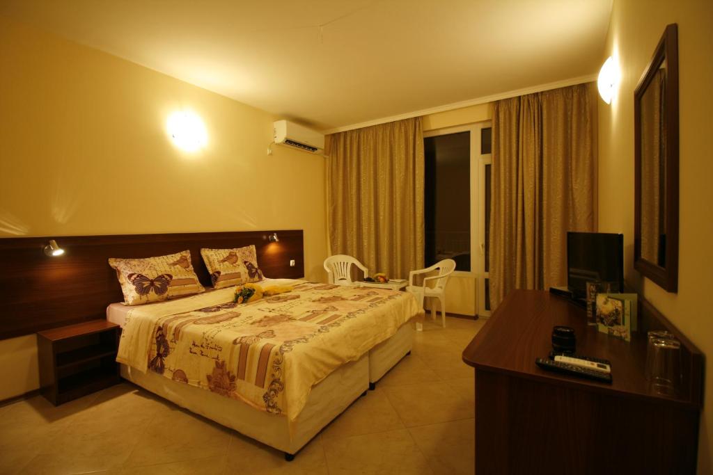 a hotel room with a bed and a television at Hotel Marant in Sozopol