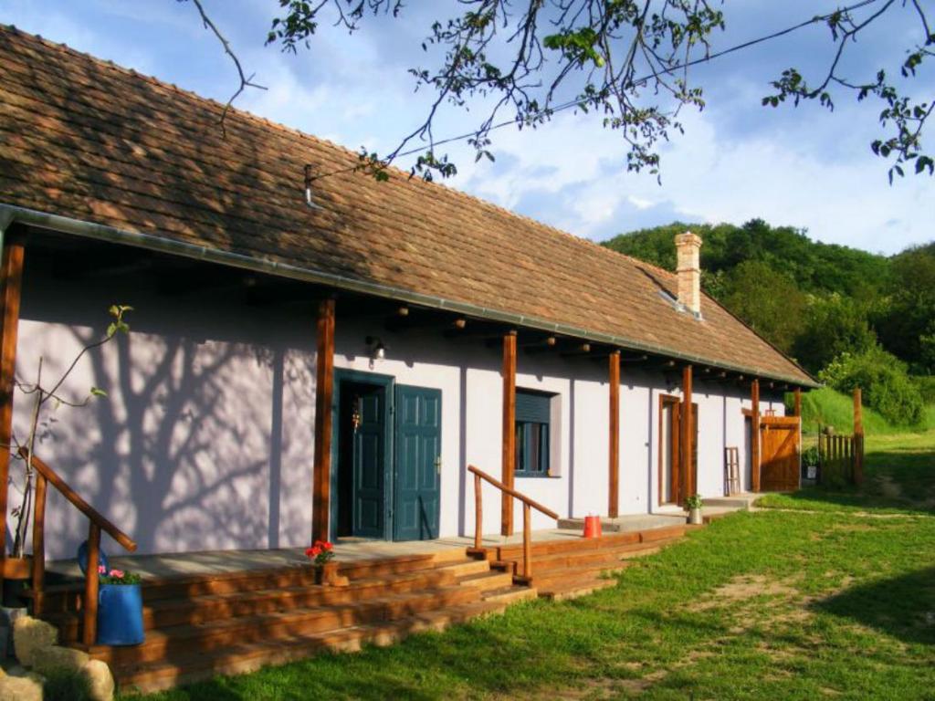un cottage bianco con portico e porta verde di Bakancstanya a Kétbodony