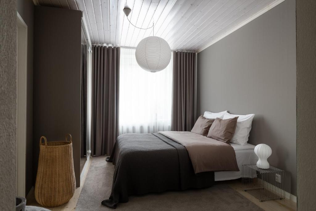 a bedroom with a bed and a large window at Stylish & Cozy 1BR Apt in Historical Neighborhood in Tampere