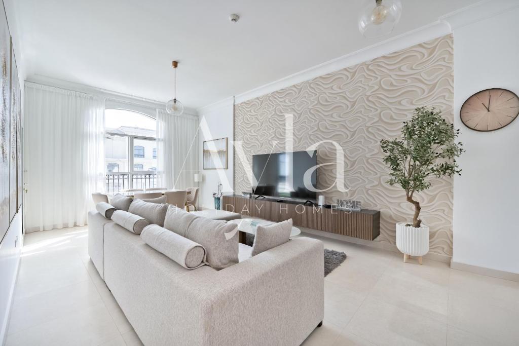 uma sala de estar com um sofá branco e uma TV em Two - Bedroom Crown Jewel on Yas island by Ayla em Yas Island