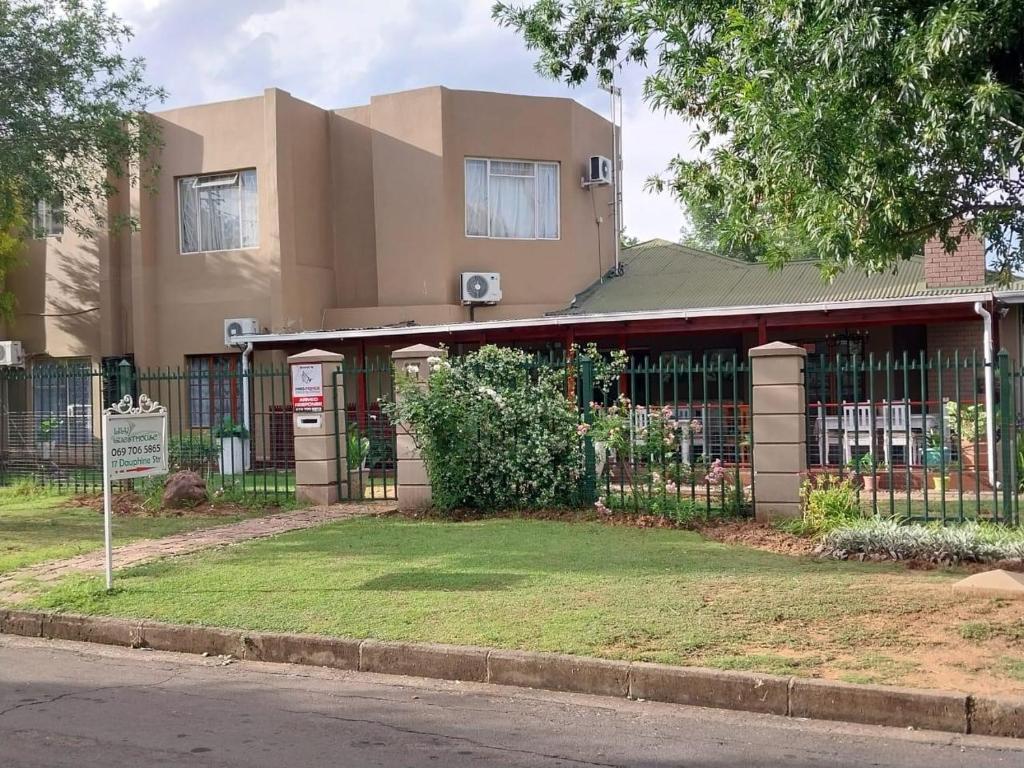 a building with a fence in front of it at Lily Guesthouse in Bloemfontein