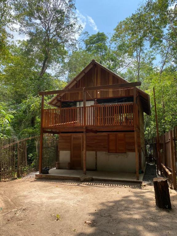 a large wooden cabin with a balcony in the woods at Alter Chale in Santarém