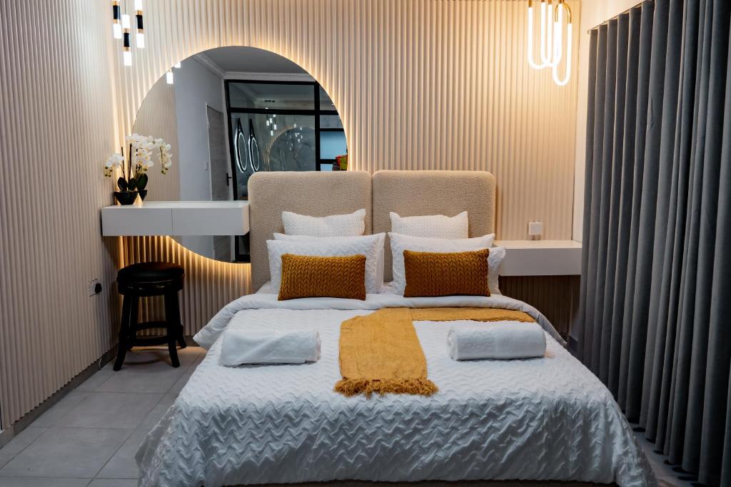 um quarto com uma cama grande com almofadas laranja e branca em Nexovant Furnished Apartments em Maun