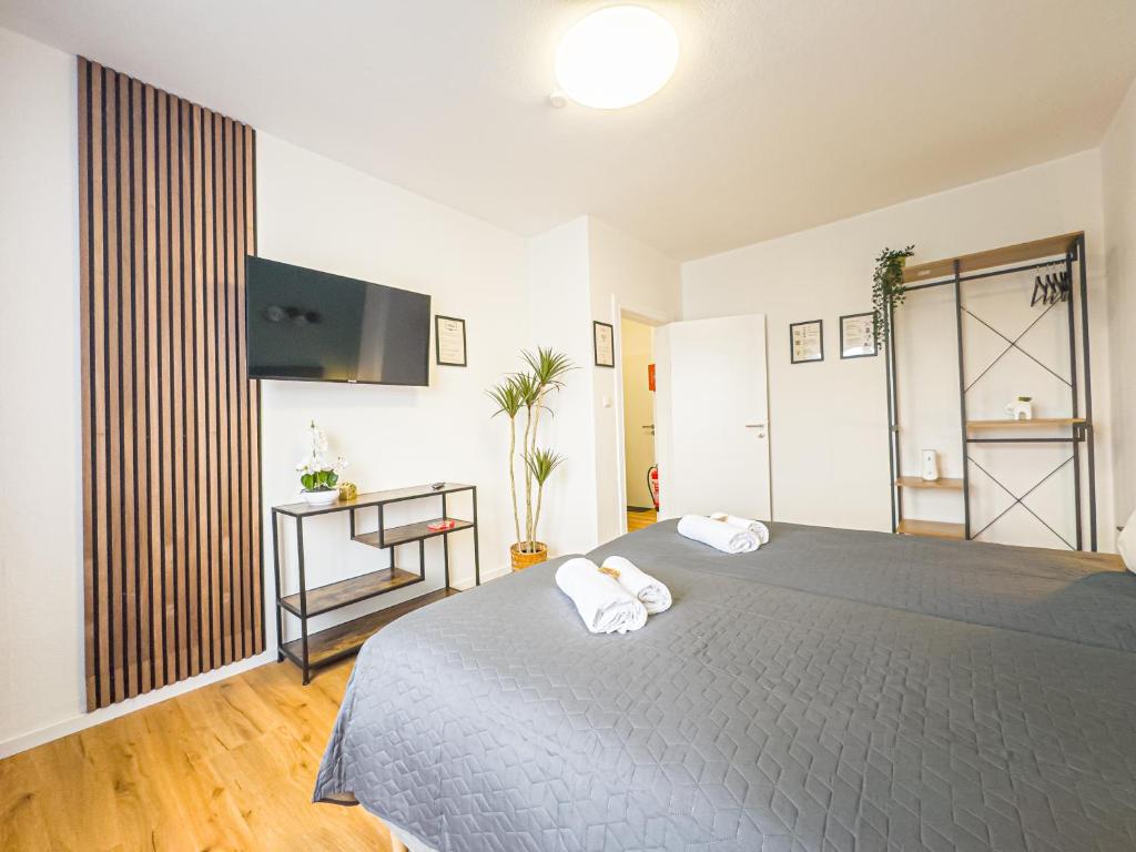 a bedroom with a large bed with two towels at ImmoStay- Neustadt Apartments, TV & WiFi in Bremen