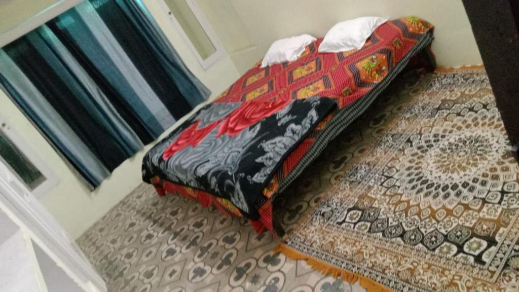 ein Bett in einem Zimmer mit einem Teppich in der Unterkunft ganga kashi niwas in Varanasi