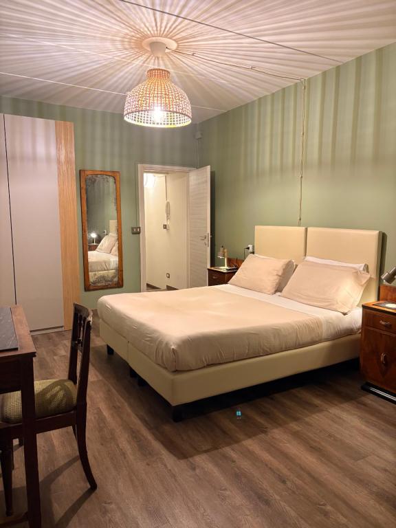 ein Schlafzimmer mit einem großen Bett und einem Kronleuchter in der Unterkunft Nottetempo in Cesena