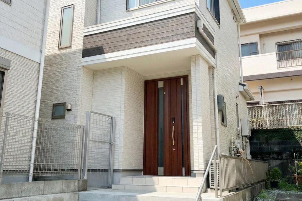 a house with a wooden door on a building at Riverside Mizukiリバーサイドミズキ in Uruma