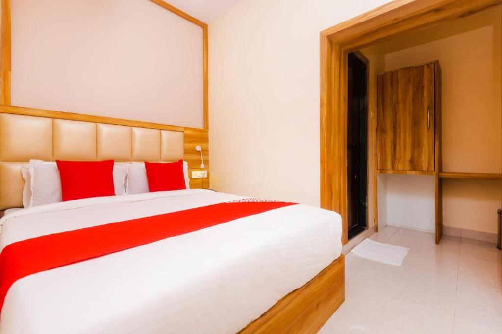 a bedroom with a large bed with red pillows at Hotel Amber Sun City in Mumbai