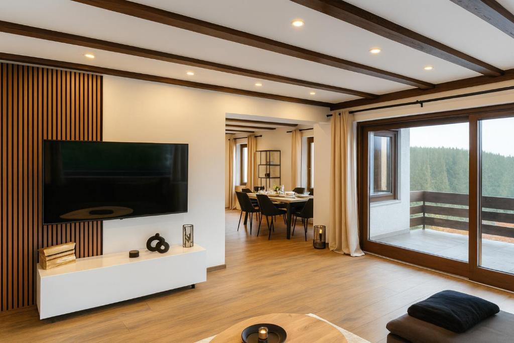 ein Wohnzimmer mit einem großen Flachbildfernseher an der Wand in der Unterkunft Alpentraum: Luxuswohnung mit atemberaubendem Blick in Buchenberg